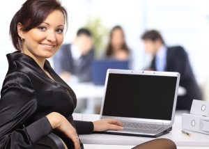Woman using laptop and smiling.