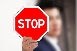 Stop Design Ideas in PowerPoint represented by a person holding a stop sign.